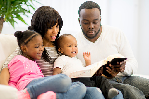 father leading family in Bible study